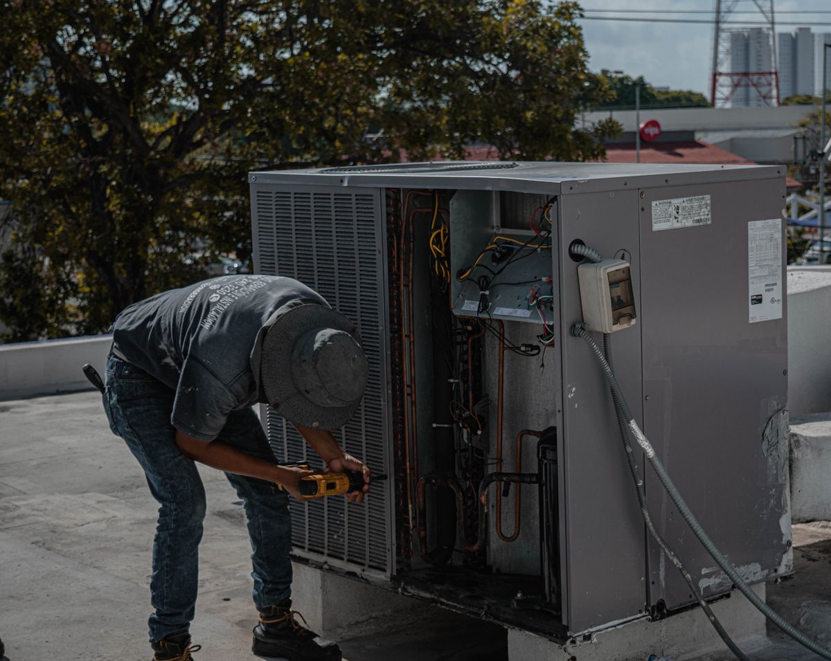 Technician servicing a rooftop air-conditioning unit